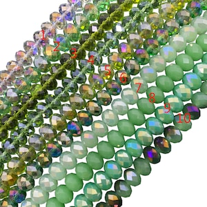 May include: Ten strands of faceted glass beads in various shades of green. The beads are arranged in a gradient from clear to dark green.