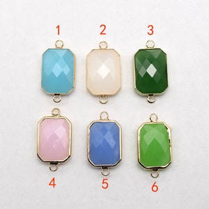 Puede incluir: Seis abalorios rectangulares de vidrio con marcos y lazos de metal dorado. Los abalorios son de varios colores: azul claro, blanco, verde, rosa, azul claro y verde.