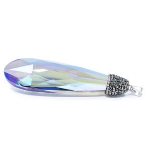 May include: A teardrop-shaped crystal pendant with a silver-toned metal setting. The crystal is iridescent and has a blue, green, and purple hue.