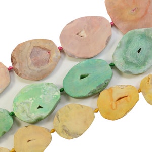 Peut inclure: Un collier de perles de pierre d'agate de différentes couleurs, notamment rose, vert, jaune et blanc. Les perles sont de forme ovale et ont une finition naturelle et polie.
