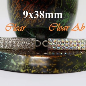 May include: Two silver-toned metal bar connectors with clear crystal rhinestones. The bar is 9x38mm. One bar has clear rhinestones and the other has clear AB rhinestones.
