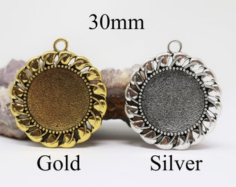 May include: Two 30mm round metal pendant blanks, one gold and one silver, with a decorative swirl design around the edge.