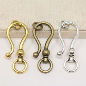 May include: Three metal keychains with a hook and a ring. The keychains are gold, bronze, and silver.
