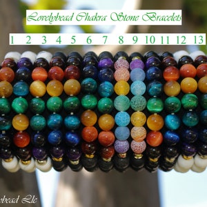 May include: Thirteen chakra stone bracelets, each with a different colour and pattern. The bracelets are numbered 1 through 13. Lovelybead Chakra Stone Bracelets. Lovelybead Llc.
