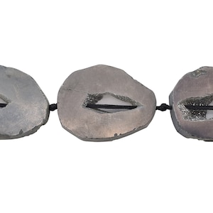 May include: Three gray agate slices with a hole in the center, strung together with black cord.