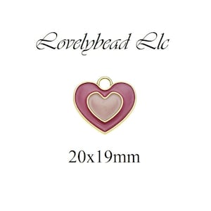May include: A pink and gold heart-shaped charm with a smaller heart inside. The charm is 20x19mm.