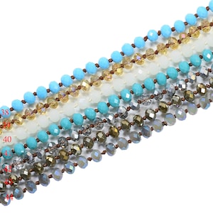 May include: A strand of turquoise blue, white, and clear faceted glass beads with brown string.