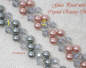 Op de afbeelding: Twee strengen van een ketting met grijze glazen parels en heldere kristallen kralen. De ketting ligt op een witte stoffen achtergrond. De tekst "Glass Pearl with Crystal Rosary Chain" is zichtbaar in de afbeelding.
