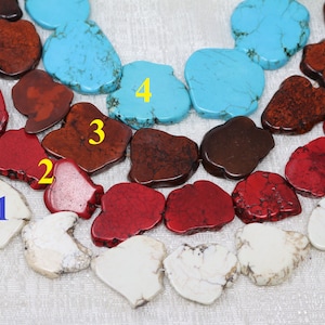May include: A close-up of a strand of turquoise, red, and white gemstone beads. The beads are all irregular in shape and have a natural, polished finish. The beads are arranged in a pattern of four colors, with the turquoise beads at the top, followed by the red beads, then the white beads, and finally the brown beads.