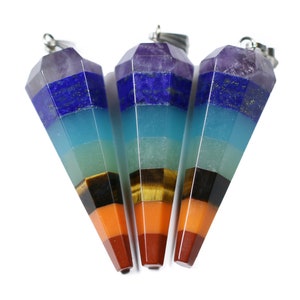 May include: Three seven chakra crystal point pendants with silver tone bail. The pendants are layered with amethyst, lapis lazuli, turquoise, green aventurine, tiger's eye, carnelian, and red jasper.