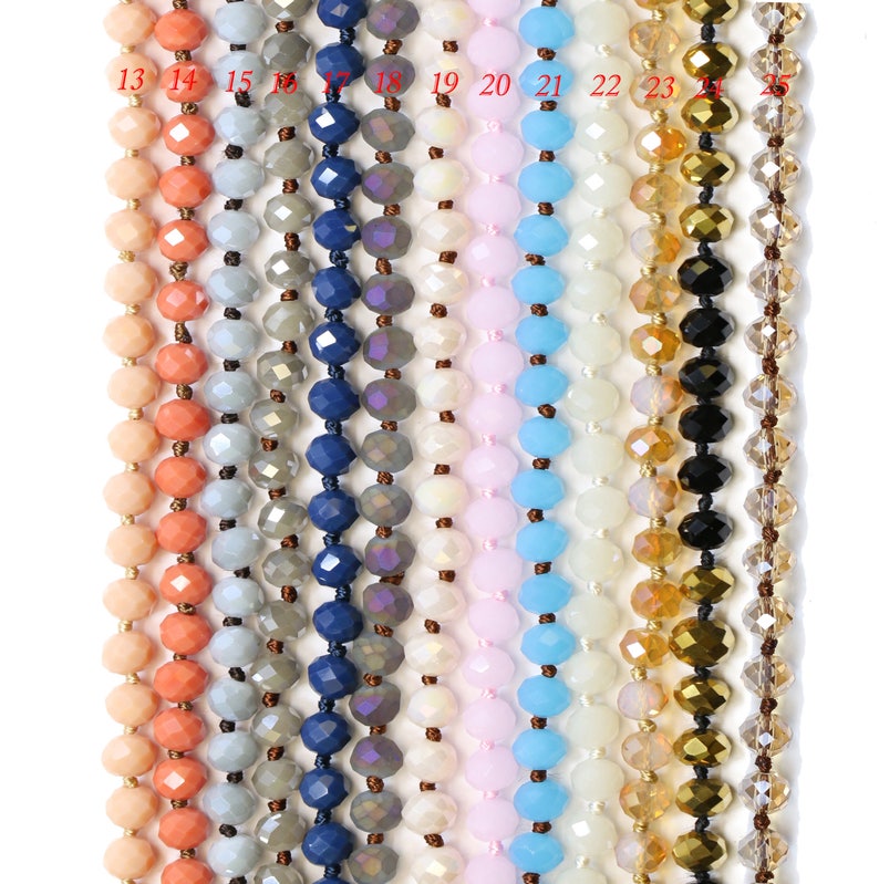 May include: A selection of 12 strands of faceted glass beads in various colors, including peach, gray, blue, white, pink, light blue, gold, and black. The beads are strung on a clear thread.