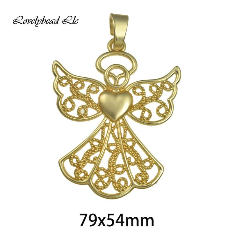 May include: Gold filigree angel pendant with a heart in the center. The pendant measures 79x54mm.