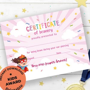 Puede incluir: Un certificado rosa imprimible de "Certificado de valentía" con un gráfico de superhéroe, texto y una medalla de oro con una cinta azul. El certificado es por ser valiente durante una perforación de oreja.