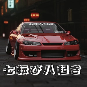 May include: A red sports car with a black and white sticker on the windshield that says "七転び八起き". The car has a black front bumper and black side skirts. The car is parked on a street with a brick sidewalk.