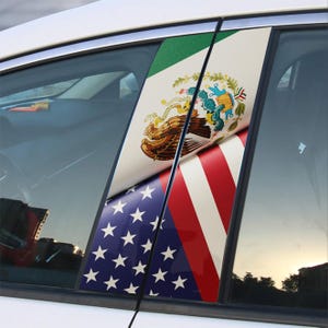 May include: Car window decals featuring the flags of Mexico and the United States. The Mexican flag is green, white, and red with the coat of arms. The American flag is blue with white stars and red and white stripes.
