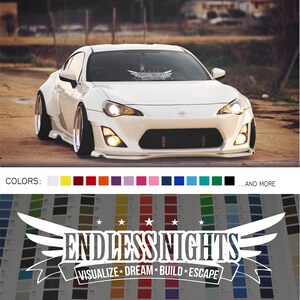Puede incluir: Coche blanco con una calcomanía en blanco y negro en el parabrisas que dice "Endless Nights" con alas a cada lado. La calcomanía también dice "Visualize Dream Build Escape".