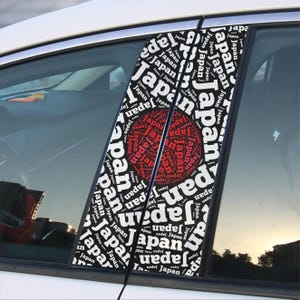 May include: Four black and white car window decals with the word "Japan" repeated in a circular pattern. The center of each decal features a red circle with the word "Japan" repeated in a smaller font.