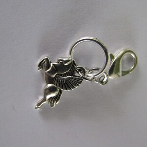 May include: Silver charm featuring a winged horse design with a silver lobster clasp.