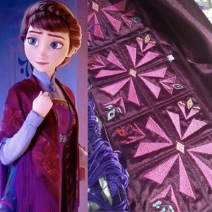 May include: A close-up of a purple fabric with pink embroidery of a snowflake design. The fabric is part of a costume, possibly for a character from a popular animated film.