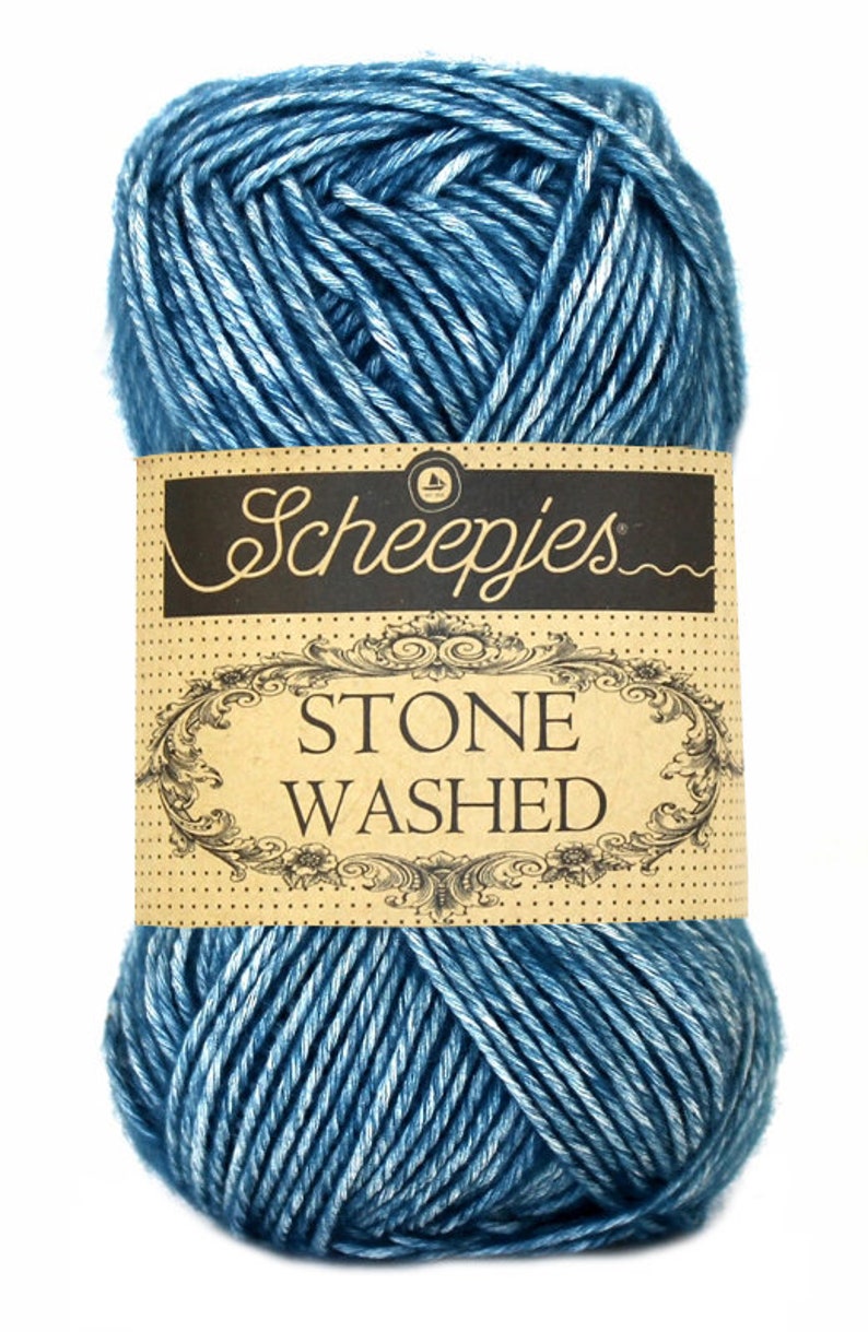 May include: A skein of blue yarn with white streaks, labeled "Scheepjes Stone Washed."