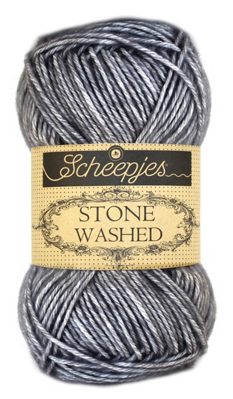 May include: A skein of gray yarn with a white sheen. The yarn is labeled "Scheepjes Stone Washed."