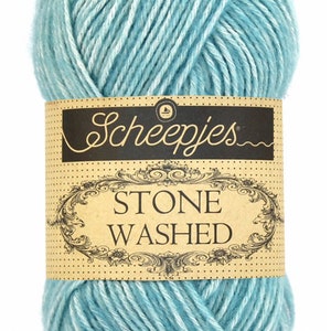 May include: A ball of light blue yarn with white streaks. The yarn is labeled "Scheepjes Stone Washed."