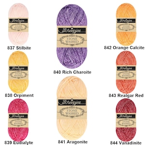 May include: Assortment of Scheepjes Stone Washed yarn in various colors, including pink, purple, orange, yellow, red, and brown. Each skein has a label with the brand name and the words "Stone Washed".