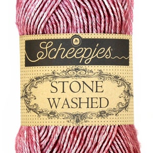 May include: A skein of pink and white yarn with a brown label that reads "Scheepjes Stone Washed".