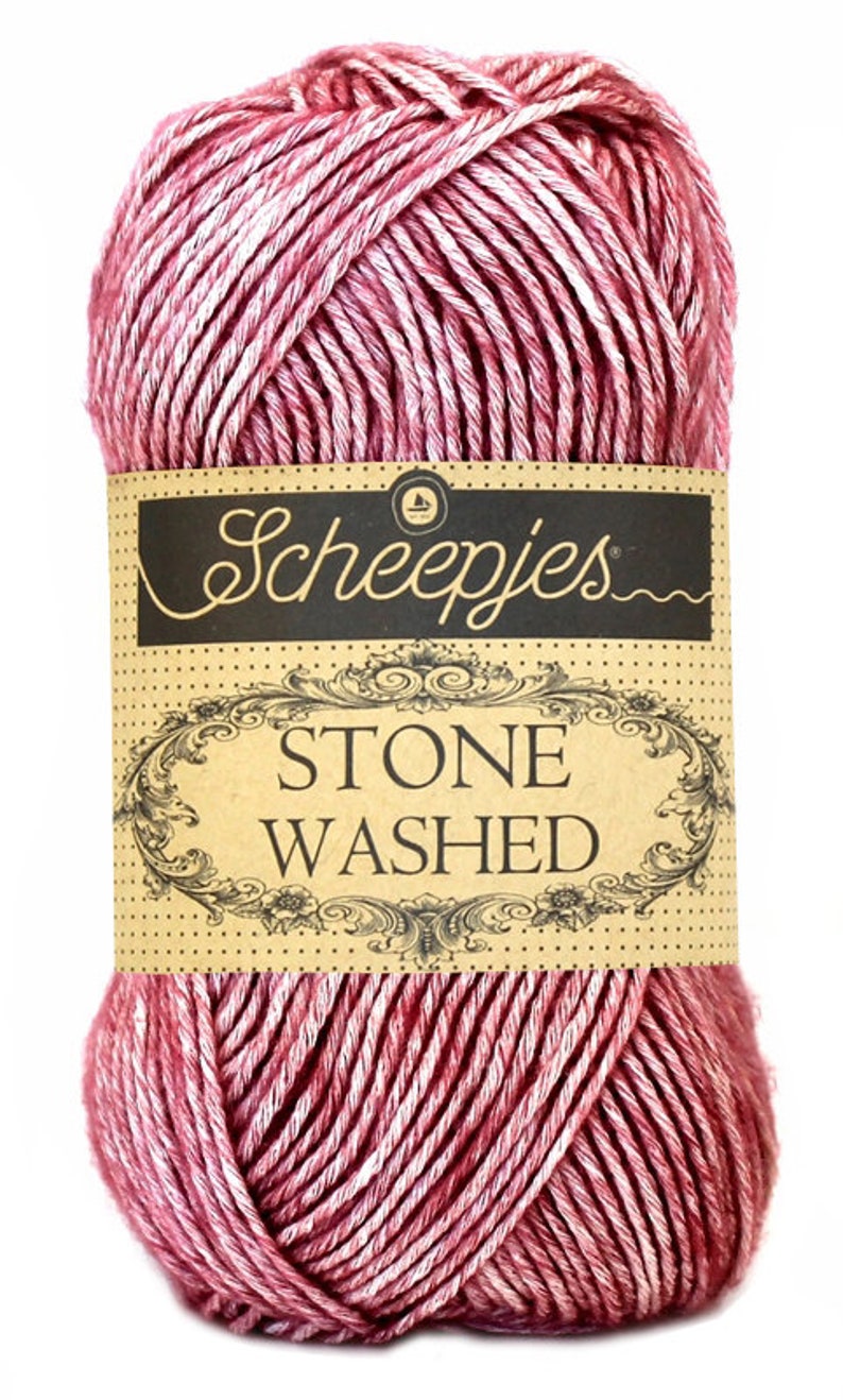May include: A skein of pink and white yarn with a brown label that reads "Scheepjes Stone Washed".