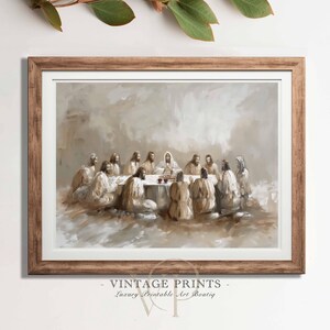 Puede incluir: Una impresión enmarcada de una pintura religiosa que representa una reunión de figuras alrededor de una mesa. La obra de arte presenta tonos apagados de beige, marrón y blanco, con un enfoque en las figuras centrales. El marco es de un color cálido de madera natural. El texto "VINTAGE PRINTS - Luxury Printable Art Boutiq" está en la parte inferior.
