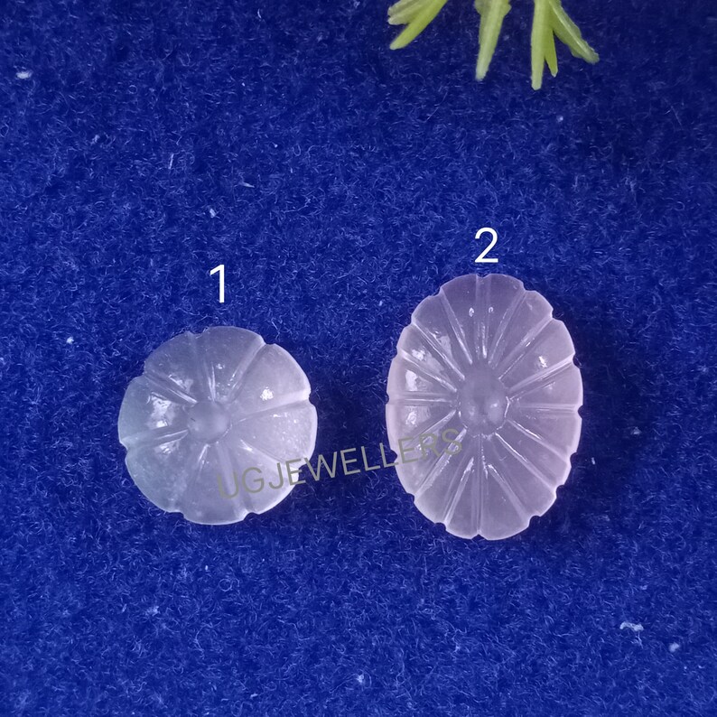 Puede incluir: Dos cabujones de cuarzo rosa tallados, uno redondo y otro ovalado, con un dise&ntilde;o de estrella. Los cabujones est&aacute;n etiquetados como 1 y 2.
