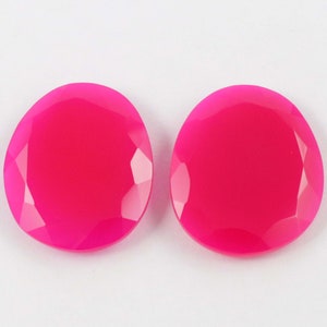 Puede incluir: Dos cabujones de piedra preciosa redondos, facetados y de color rosa brillante.