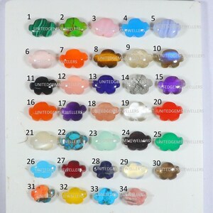 Pode incluir: Uma coleção de 34 cabochões de pedras preciosas de diferentes cores em forma de nuvem. Os cabochões estão dispostos em filas de cinco, com os números de 1 a 34 impressos acima de cada pedra.