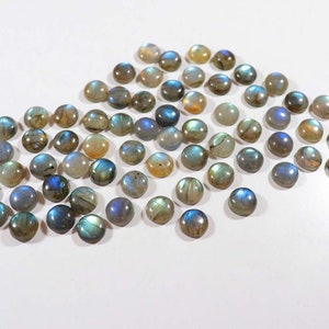 Pu&ograve; includere: Una collezione di pietre preziose rotonde di labradorite iridescente. Le pietre sono di varie tonalit&agrave; di blu, verde e grigio con una finitura scintillante e opalescente.