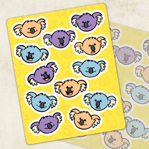May include: Sheets of koala bear stickers in various colors, including orange, purple, and blue. The stickers have a cartoon design with a yellow background and a repeating pattern of cat faces.