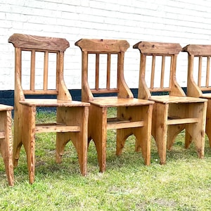 May include: Six wooden chairs with a simple design, featuring a slatted back and a shelf underneath the seat. The chairs are all made of natural wood and have a rustic, farmhouse style.
