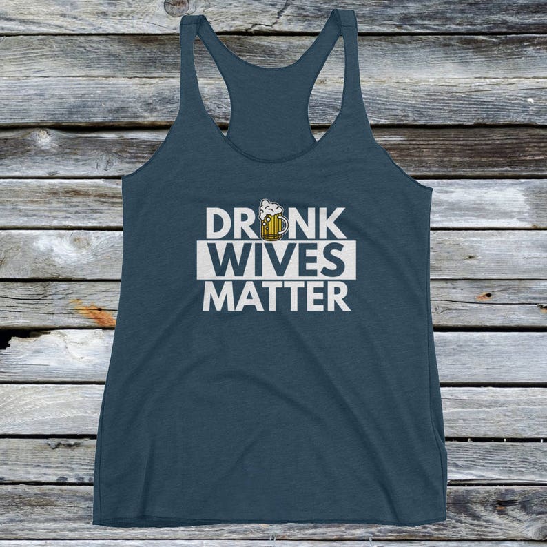 Op de afbeelding: Een donkerblauw tanktop met een witte afbeelding waarop "DRUNK WIVES MATTER" staat met een cartoon bierglas boven de tekst.