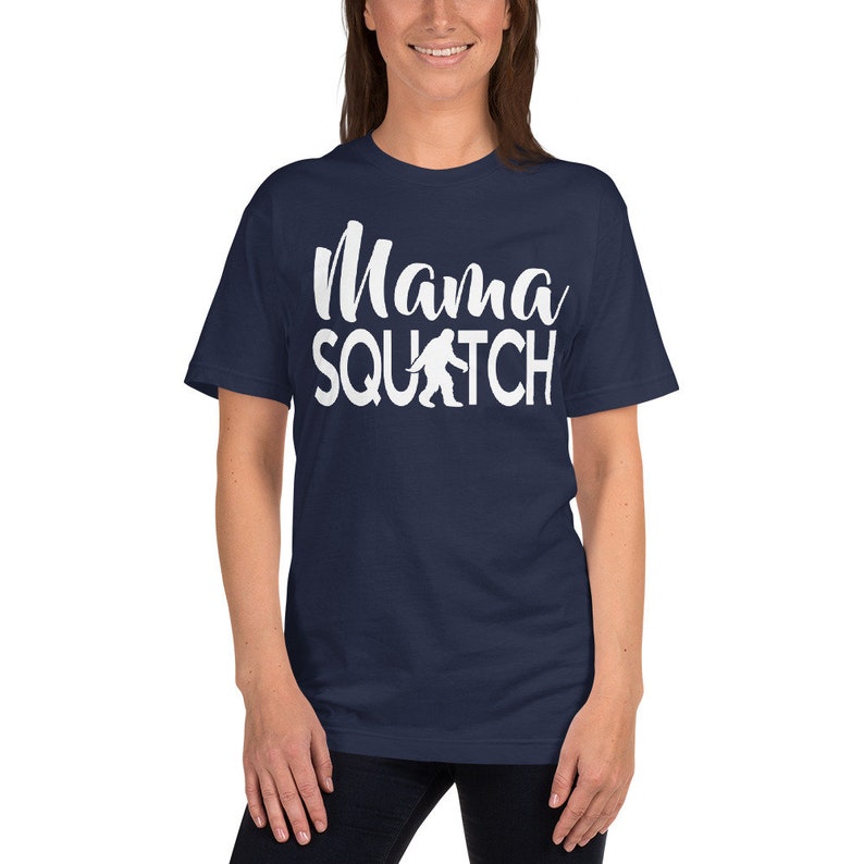 May include: A navy blue t-shirt with white text that reads "Mama Squatch" and a white silhouette of Bigfoot.