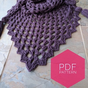 May include: A purple crochet shawl with a lacy pattern and tassels. The shawl is folded and laid on a tiled surface. The text "PDF PATTERN" is on a pink hexagon.