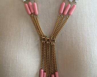 May include: A gold chain necklace with pink and white beads. The necklace has a tassel of gold chains and pink beads.