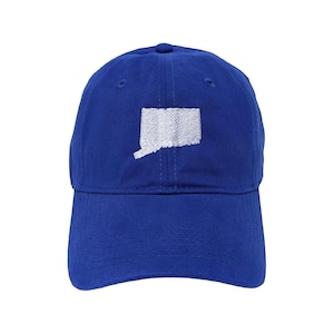 May include: A royal blue baseball cap featuring a white embroidered outline of the state of Connecticut centered on the front panel. The hat has a curved brim, a button on the top, and stitched eyelets for ventilation on the crown panels.