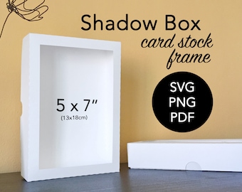 May include: White shadow box frame for a 5x7 inch (13x18 cm) photo or artwork. The frame is made of card stock and comes in SVG, PNG, and PDF formats.