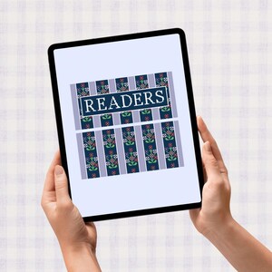 May include: A tablet displays a cross-stitch design with the word "READERS" in a white frame. The design features vertical stripes in blue and lavender, with floral patterns in red, green, and blue.