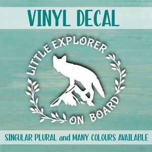 Pode incluir: Vinil autocolante branco com o texto "VINYL DECAL" no topo. O autocolante apresenta uma silhueta branca de uma raposa em pé numa montanha, rodeada por uma coroa e as palavras "LITTLE EXPLORER ON BOARD". O texto "SINGULAR PLURAL and MANY COLOURS AVAILABLE" está na parte inferior.