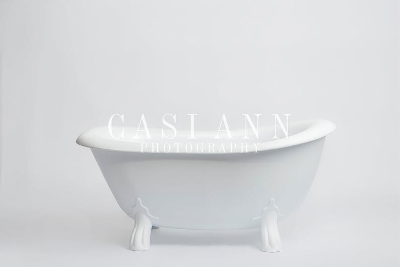 Puede incluir: Ba&ntilde;era de porcelana blanca con cuatro patas decorativas. La ba&ntilde;era est&aacute; sobre un fondo blanco.