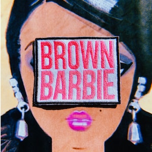 May include: A white patch with black stitching features the text "BROWN BARBIE" in pink embroidered letters.