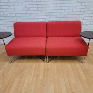 May include: A red two-seater sofa with a chrome frame and two matching side tables with dark wood tops.