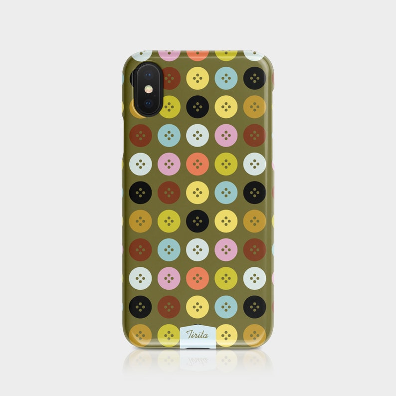 Puede incluir: Una funda de tel&eacute;fono verde con un patr&oacute;n de botones coloridos. La funda tiene una lente de c&aacute;mara negra y el texto "Tirita" en la parte inferior.