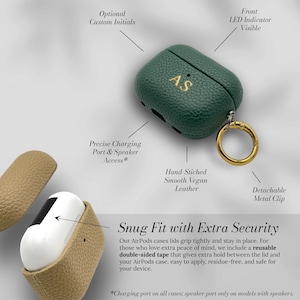 May include: Green vegan leather AirPods case with gold initials "AS" and a gold metal clip. The case has a textured finish and includes a charging port and speaker access. The text "Snug Fit with Extra Security" is also visible.