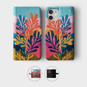 May include: A colorful phone case with a vibrant floral design. The case features a combination of pink, blue, orange, and yellow hues, with a snap closure. The design is repeated on the phone case and the phone is visible.